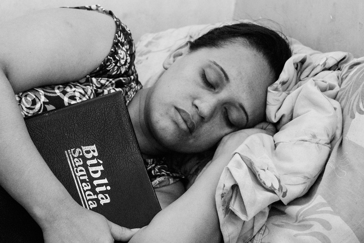 Woman sleeping holding her Bible.